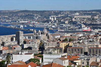 High angle view of townscape by sea against sky