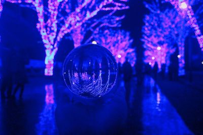 Close-up of illuminated crystal ball on glass at night