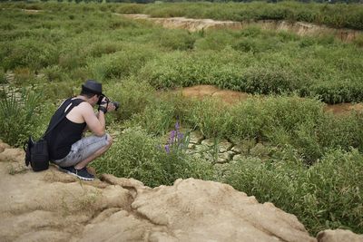 Travel photographer making photo of the nature. man in a hat.	