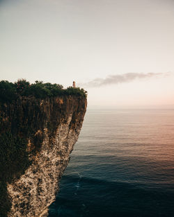 Rock formations by sea against sky