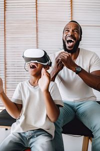African family father and son playing a game using vr headsets.ai generated