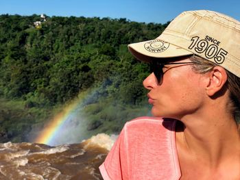 Woman wearing sunglasses against landscape and sky