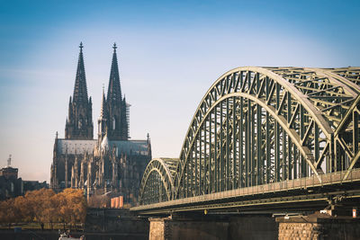 Arch bridge over river against buildings in city