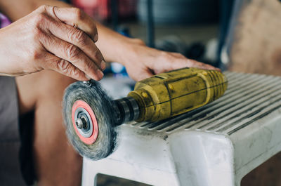 Midsection of man using grinder on table in workshop