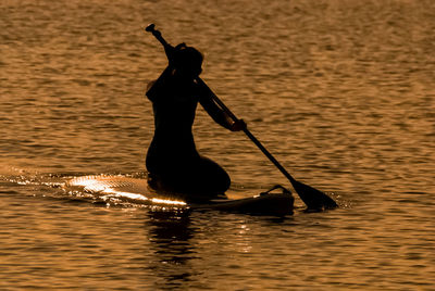 Silhouette of woman paddling