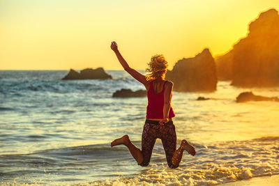 Rear view of person on beach during sunset