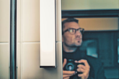 Portrait of man photographing through camera