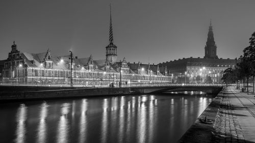 Bridge over river in city against sky