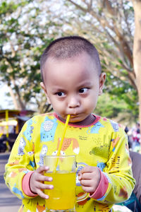 Portrait of a boy sipping an orange iced drink