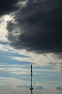 Low angle view of silhouette communications tower against sky during sunset