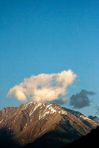 Snowcapped mountain with a cloud on the top in the sunset