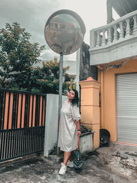 Full length of woman standing by building