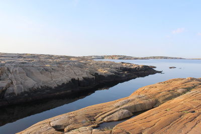 Rock formations by sea against sky