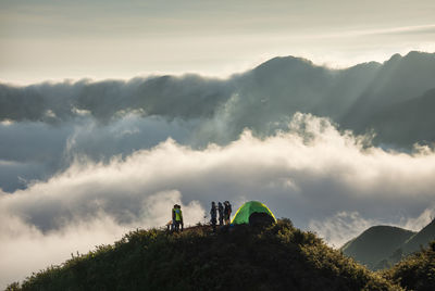 People on mountain against sky
