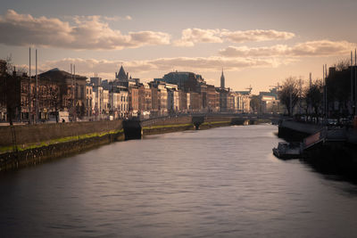 Bridge over river against buildings in city