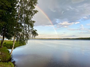 Scenic view of lake against rainbow in sky