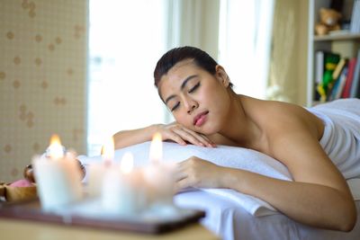 Mid adult woman lying on sofa at home