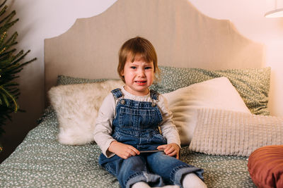 Portrait of young woman sitting on sofa at home