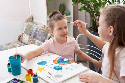 Sisters painting at home