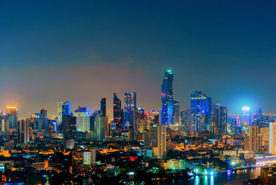 Illuminated buildings in city against sky at night