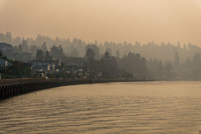 Smoke fills the air with waterfront homes and a boardwalk below in redondo beach, washington.