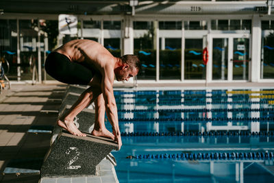 Side view of shirtless man in swimming pool