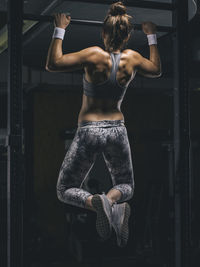 Female athlete exercising chin-ups