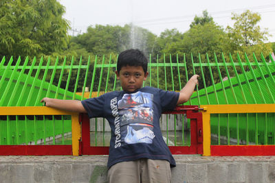 Portrait of boy standing against wall