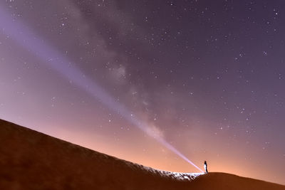 Silhouette woman standing against star field at night