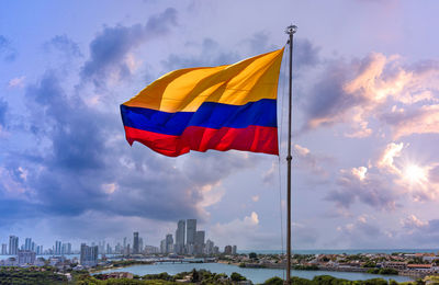 Low angle view of flag against buildings in city