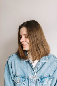 Portrait of smiling young woman against white background