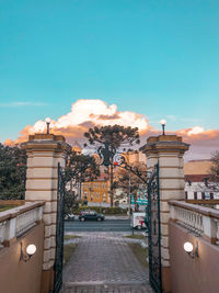 Street amidst buildings against sky during sunset