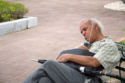 Man listening radio while sleeping on chair