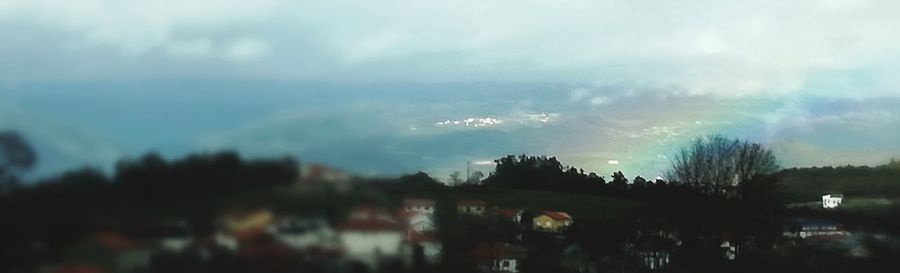 Panoramic view of trees and buildings against sky