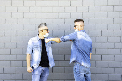 Man and woman standing against wall