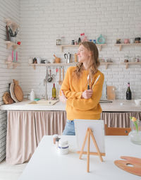 Portrait of young woman sitting on table