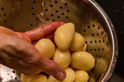 High angle view of hand holding eggs in container