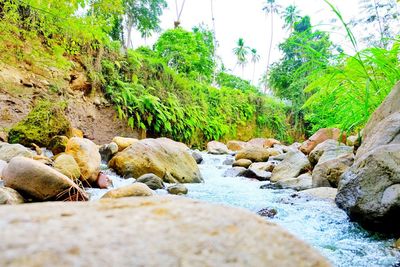 Rocks by river against sky