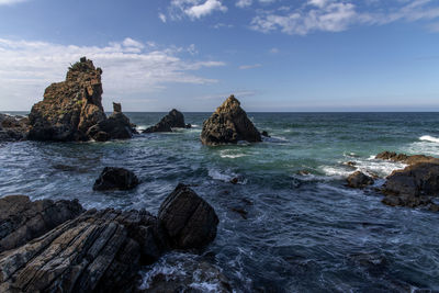 Scenic view of rocks in sea against sky