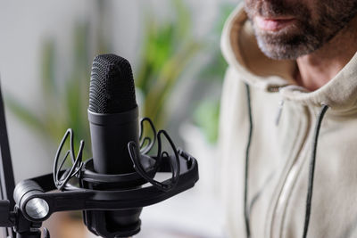 Midsection of man holding microphone