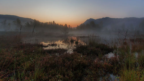 Scenic view of lake against sky during sunset