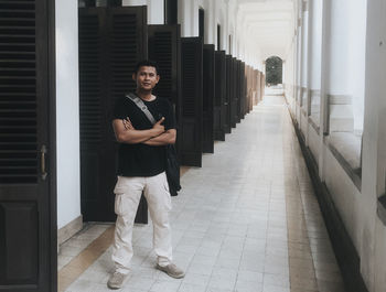Portrait of young man standing in corridor of building