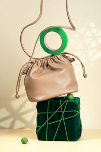 Conceptual creative modern still life, balance composition. beige handbag, velvet, rope, trendy 