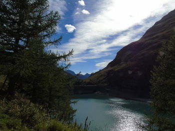 Scenic view of lake by mountains against sky