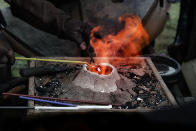 Close-up of man working on barbecue grill