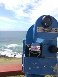 Close-up of coin-operated binoculars against sea