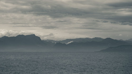 Scenic view of sea and mountains against sky