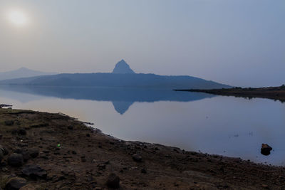 Scenic view of lake and mountains against clear sky