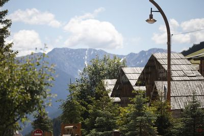 House amidst trees and buildings against sky