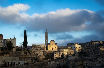 Buildings in city against cloudy sky